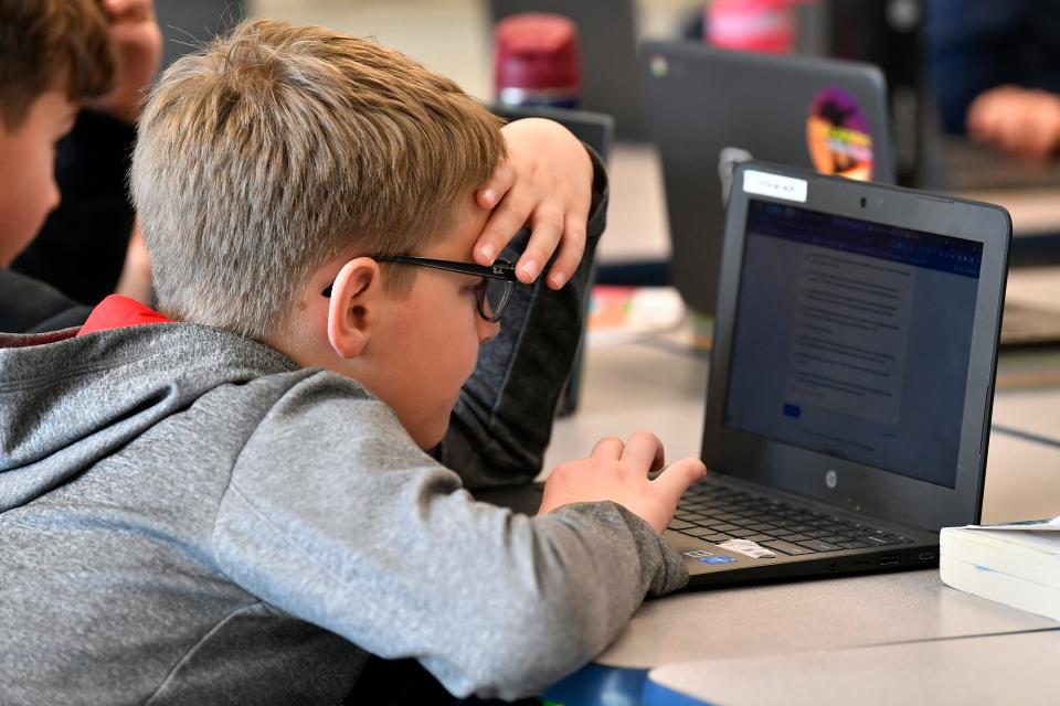 William Kelley attempts to "Find the Bot" in Donnie Piercey's class at Stonewall Elementary in Lexington, Ky., Monday, Feb. 6, 2023. Students in the class each summarized a text about boxing champion and Kentucky icon Muhammad Ali then tried to figure out which summaries were penned by classmates and which was written by the chatbot. The chatbot was the new artificial intelligence tool ChatGPT, which can generate everything from essays and haikus to term papers in a matter of seconds. (AP Photo/Timothy D. Easley) ORG XMIT: KYTE305