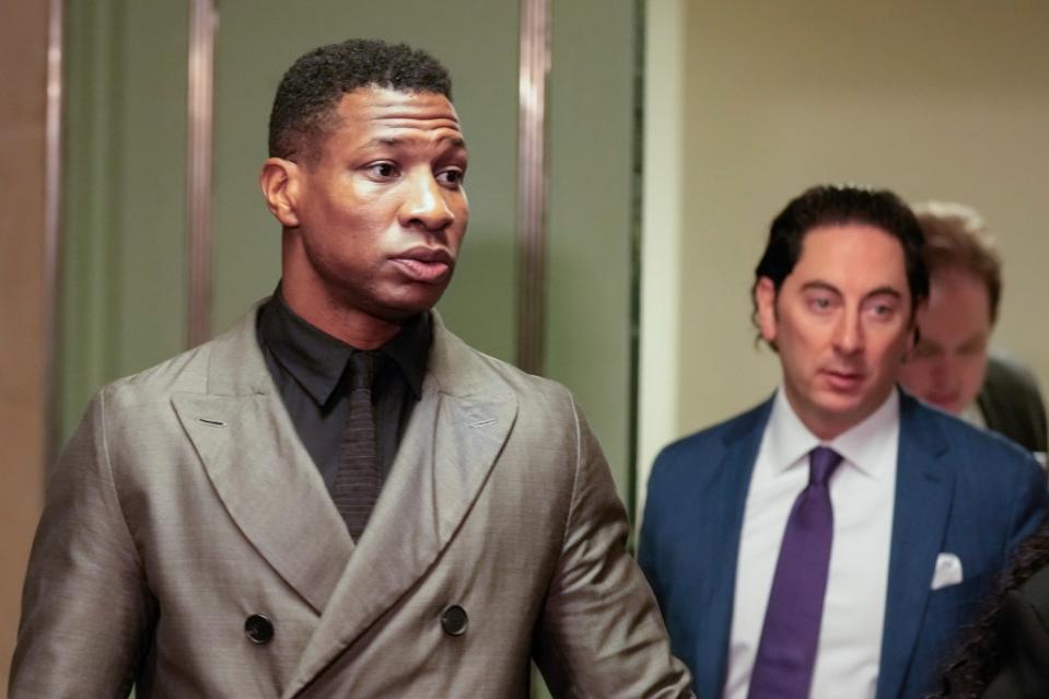 Jonathan Majors, left, enters a courtroom at the Manhattan criminal courts in New York, Monday, Dec. 18, 2023. The actor is accused of assaulting his then-girlfriend as the two struggled over a phone in the back seat of a chauffeured car. (AP Photo/Seth Wenig)