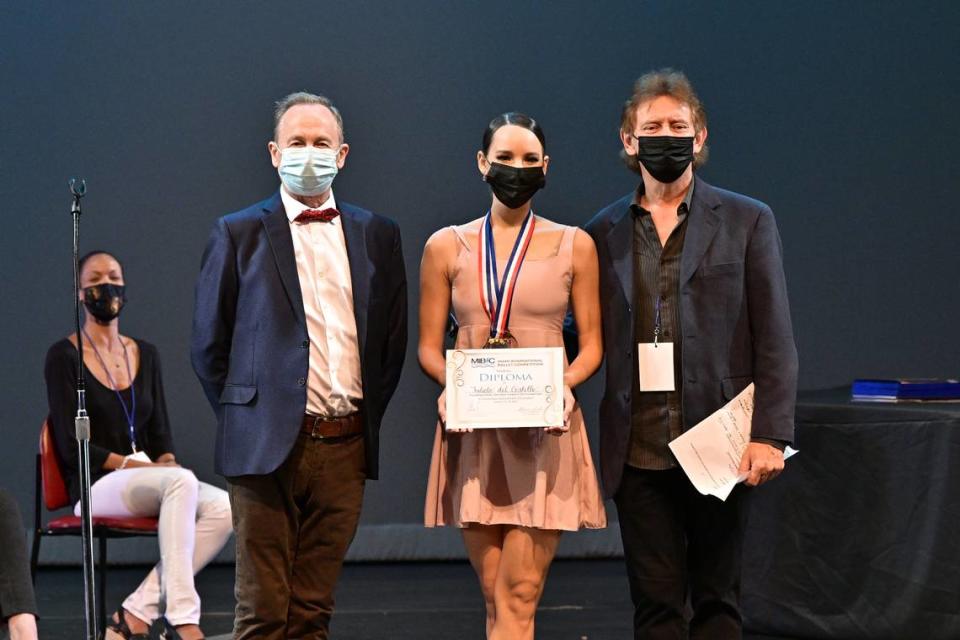 Los maestros Vladimir Issaev (izquierda) y Yanis Pikieris con Julieta del Castillo, participante que fue primer lugar en la División 4 y recibió el Premio de Estímulo de los Directores Artísticos Fundadores. 