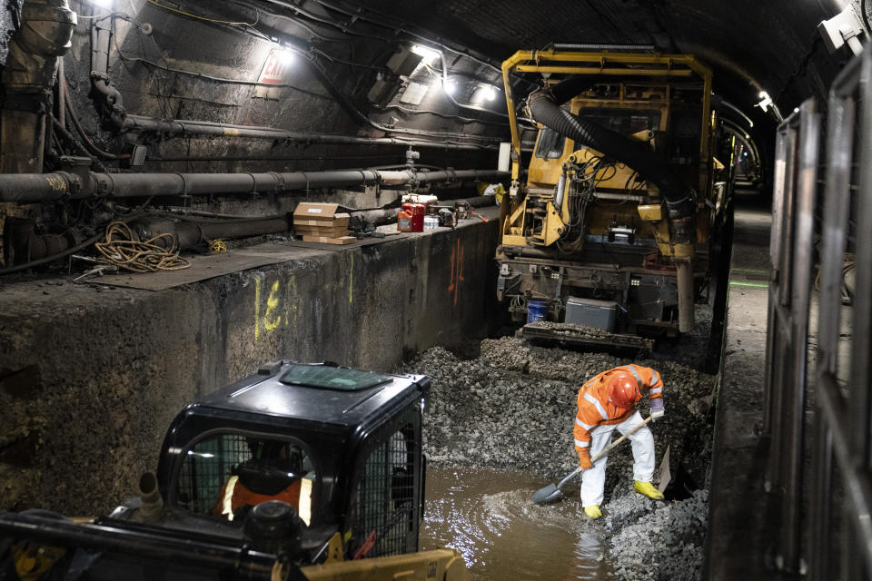 Amtrak workers perform tunnel repairs to a partially flooded train track bed, Saturday, March 20, 2021, in Weehawken, N.J. With a new rail tunnel into New York years away at best, Amtrak is embarking on an aggressive and expensive program to fix a 110-year-old tunnel in the interim. (AP Photo/John Minchillo)