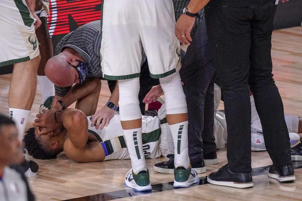 Milwaukee Bucks' Giannis Antetokounmpo reacts after hurting his ankle during the first half of an NBA conference semifinal playoff basketball game against the Miami Heat Sunday, Sept. 6, 2020, in Lake Buena Vista, Fla. (AP Photo/Mark J. Terrill)