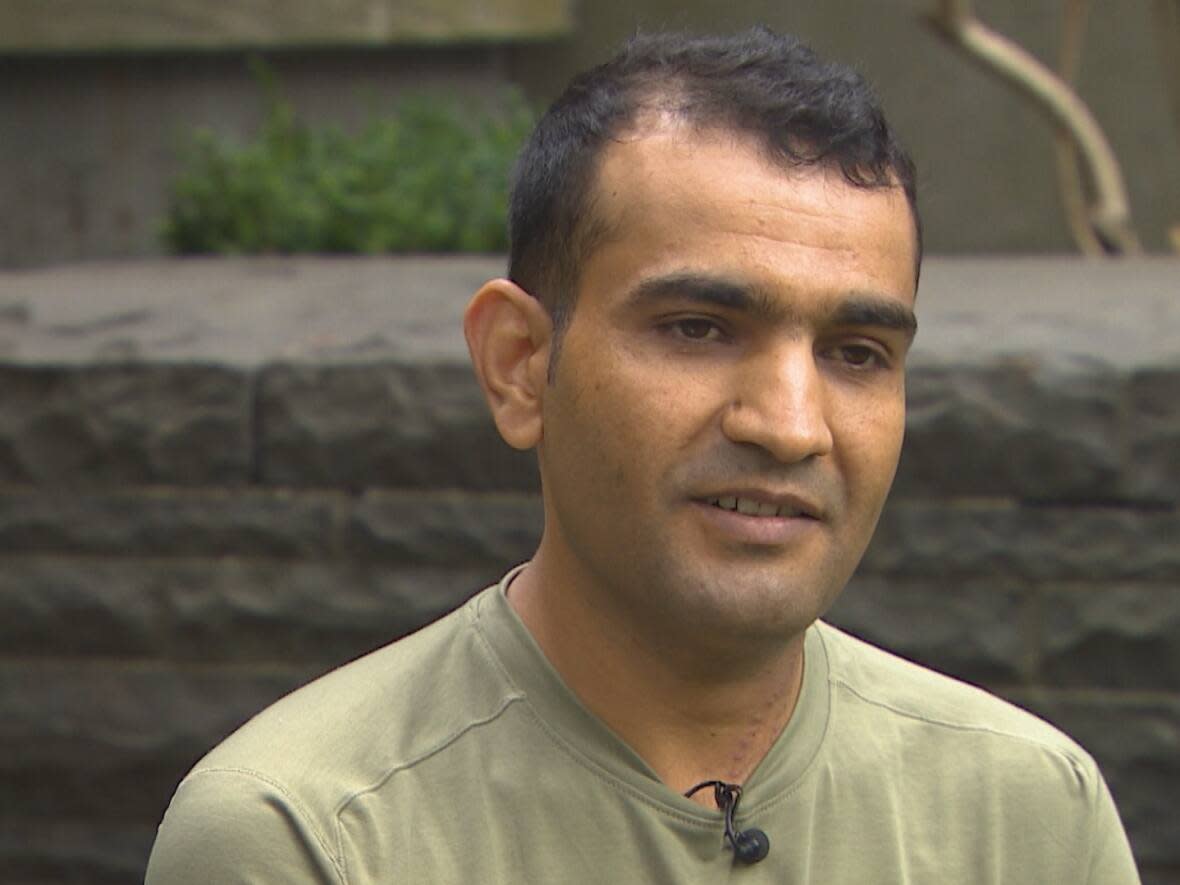 Hamid Habibi, pictured here in an interview with CBC's Anita Bathe, was delivering food in Vancouver's Chinatown when he was stabbed several times. (CBC News Vancouver - image credit)