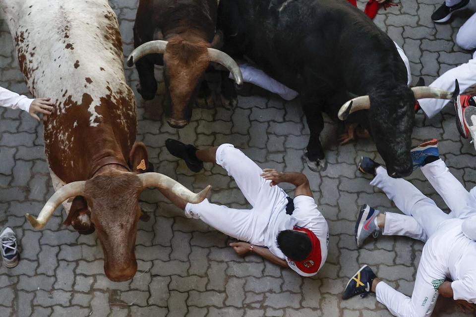 A man is almost gored during the fifth 'encierro' or running of the bulls during the San Fermin Festival in Pamplona, Navarra, Spain, 11 July 2022, Pamplona's Running of the Bulls, known locally as Sanfermines, resumed after a two-year hiatus due to the COVID-19 pandemic.