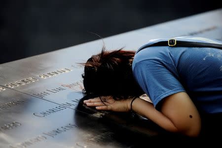 A woman lays her head on a row of names at the National September 11 Memorial, ahead of the 15th anniversary of the attacks in Manhattan, New York, September 10, 2016. REUTERS/Mark Kauzlarich