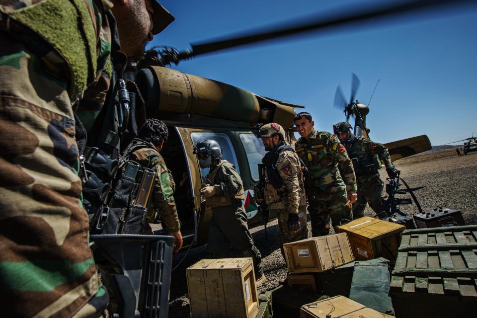 Afghan commandoes help unload ammunition from a UH-60 Blackhaw during a resupply mission to an outpost in Ghazni Province, Afghanistan, Sunday, May 9, 2021.