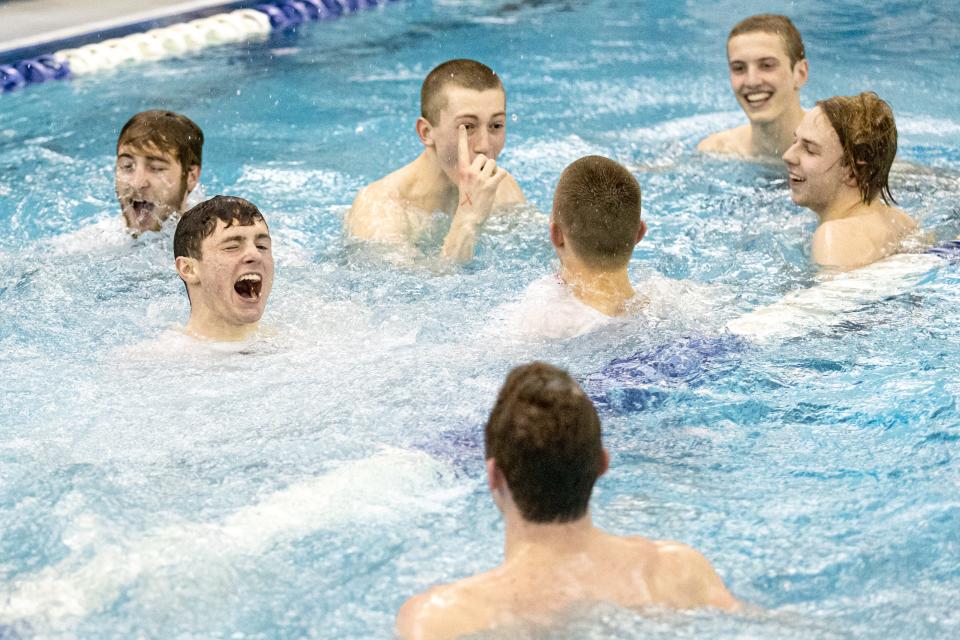 The Edmond North boys swimming team jumps into the pool after winning the Class 6A state championship Friday night at the Edmond Schools Aquatic Center.