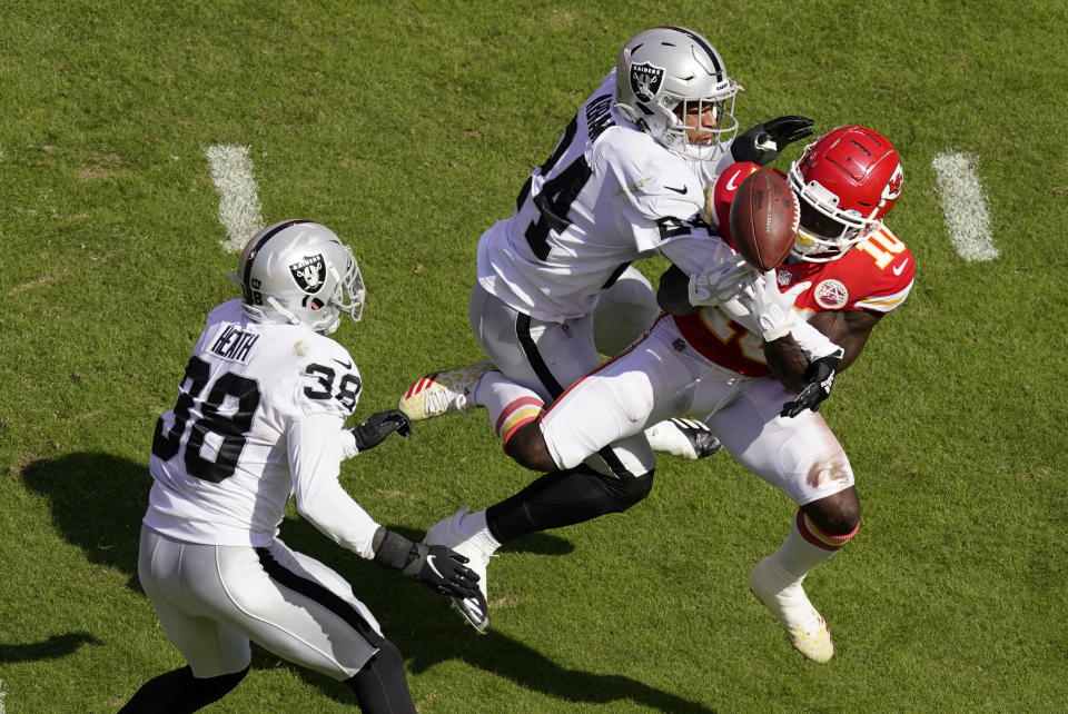 Las Vegas Raiders safety Johnathan Abram (24) and safety Jeff Heath (38) break up a pass intended for Kansas City Chiefs wide receiver Tyreek Hill (10) during the first half of an NFL football game, Sunday, Oct. 11, 2020, in Kansas City. (AP Photo/Charlie Riedel)