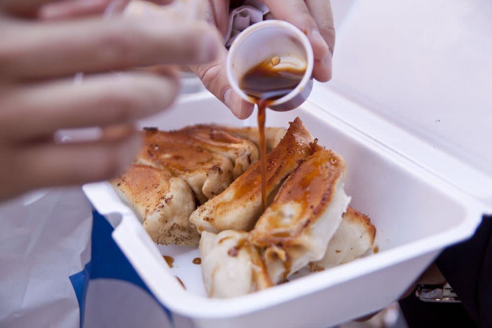 Close-up of dumplings with soy sauce poured on them.