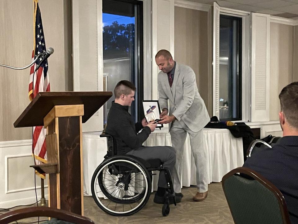 Brian Merkle (right) presents the Blue & Gold Wounded in Service Award to Detective Sgt. Devin Kachar Thursday at the Monroe Golf & Country Club.