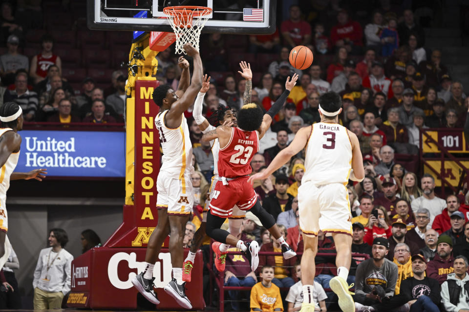 Wisconsin guard Chucky Hepburn (23) shoots over Minnesota forward Pharrel Payne, left, and guard Elijah Hawkins during the first half of an NCAA college basketball game Tuesday, Jan.23, 2024, in Minneapolis. (AP Photo/Craig Lassig)