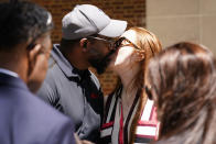 Former NFL player Clarence Vaughn III, center left, and his wife Brooke Vaughn kiss before delivering tens of thousands of petitions demanding equal treatment for everyone involved in the settlement of concussion claims against the NFL, to the federal courthouse in Philadelphia, Friday, May 14, 2021. (AP Photo/Matt Rourke)