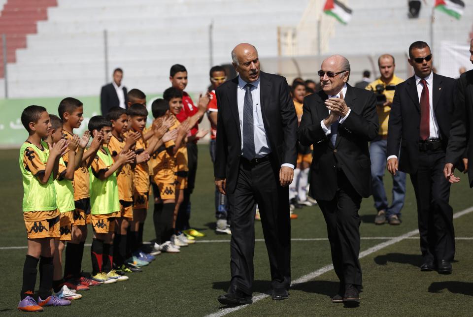 FIFA President Sepp Blatter (C) smiles as he visits a football academy named after him, near the West Bank city of Ramallah May 27, 2014. REUTERS/Mohamad Torokman (WEST BANK - Tags: POLITICS SPORT)