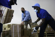 From left, Michael Stack, healthcare account representative for Grainger, Ray Fredericks, assistant director for Medisys, and Tim Williams, warehouse assistant for Medisys, load dozens of electrical transformers, which will be shipped to New Delhi with oxygen concentrators this week, on New York’s Long Island Friday, May 7, 2021. With teams deployed in India to help support COVID-19 patients, Khalsa Aid USA plans to provide a total of 500 oxygen concentrators and 500 transformers to cities throughout the country. (AP Photo/Jessie Wardarski)