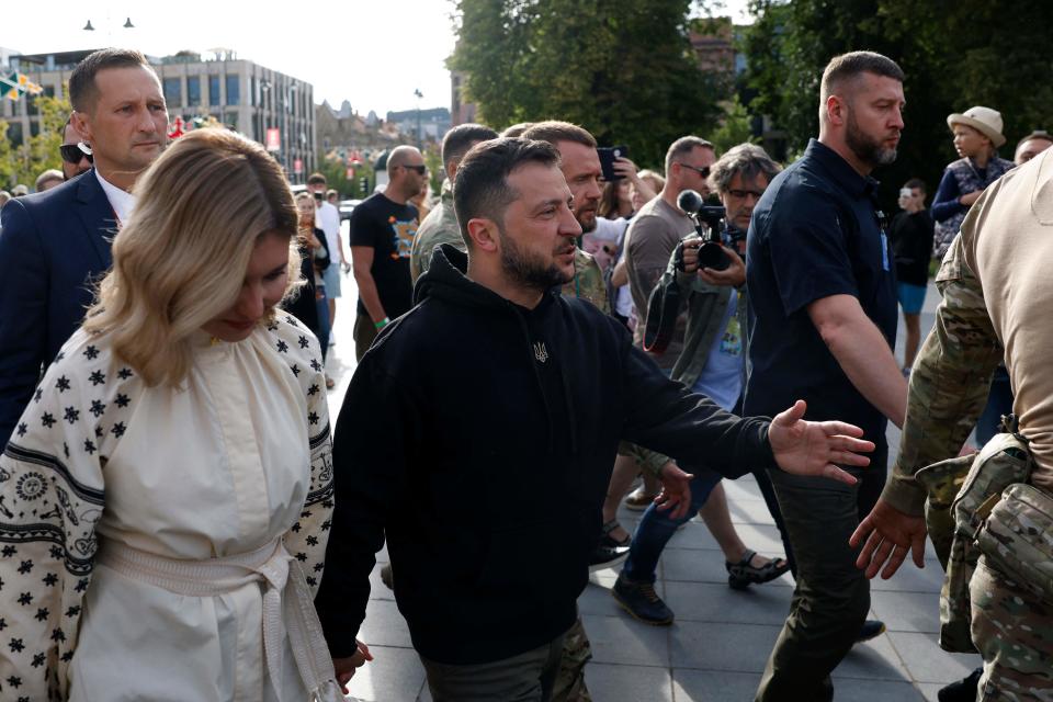 Ukrainian President Volodymyr Zelenskyy, center, with his wife Olena Zelenska, arrives to deliver a speech at Lukiskiu Square in Vilnius on Tuesday.