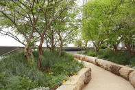 This undated photo provided by 1 Hotel in West Hollywood, Calif., shows an extension of the hotel's interior space that they are calling the "outddor lobby." The Hollywood Hills hiking trails next to the hotel were the inspiration; guests can explore a granite pathway that meanders through a 'canyon' of native greenery. Log seating and timber planters were created from salvaged Los Angeles-area fallen trees. (RCH Studios/Hunter Kerhart/1 Hotel via AP)