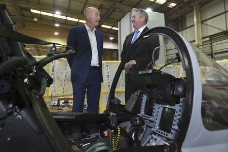 Managing Director Tony Birmingham (L) shows International Trade Secretary Liam Fox a Euro Fighter simulator, during a visit to EDM Ltd in Newton Heath, Manchester, Britain September 29, 2016. REUTERS/Anthony Devlin