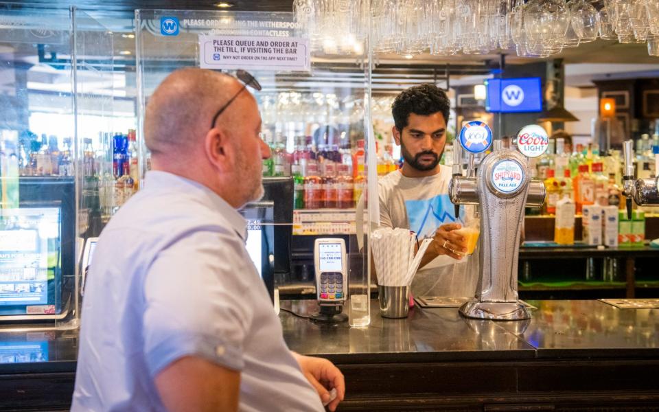 A pub-goer orders a pint at the bar in Bournemouth - Vagner Vidal/Hyde News & Pictures Ltd