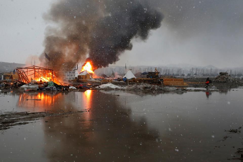 <p>Buildings burn after being set alight by protesters preparing to evacuate the main opposition camp against the Dakota Access oil pipeline near Cannon Ball, N.D., Feb. 22, 2017. (Photo: Terray Sylvester/Reuters) </p>