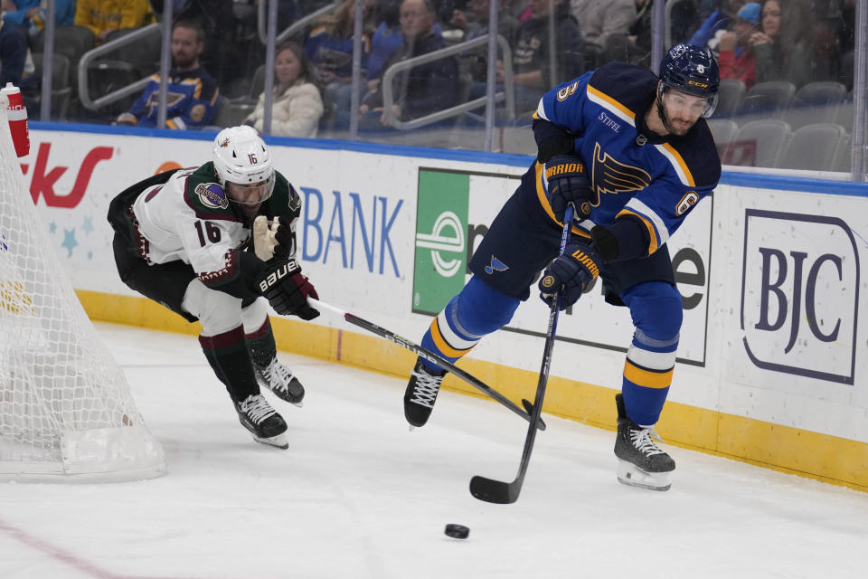 St. Louis Blues' Marco Scandella (6) passes around Arizona Coyotes' Jason Zucker (16) during the first period of an NHL hockey game Thursday, Nov. 9, 2023, in St. Louis. (AP Photo/Jeff Roberson)