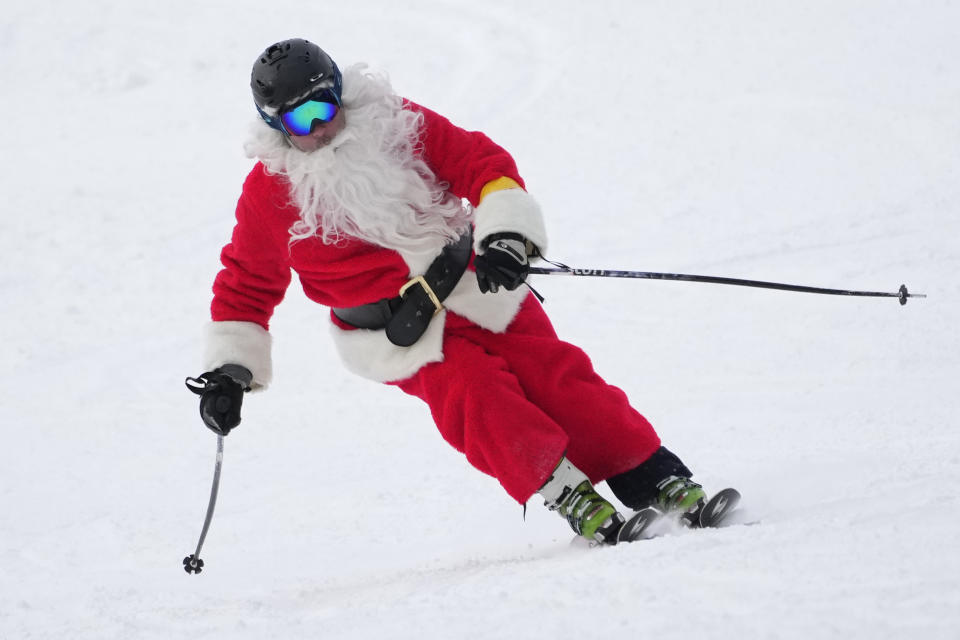 A skier dressed as Santa makes a turn in the snow as they ski down a run at the Newry resort.