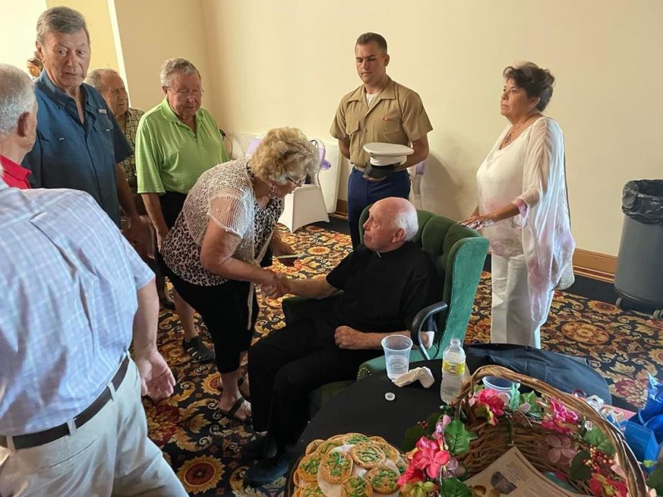 Monsignor David Page greets guests for his 90th birthday party.