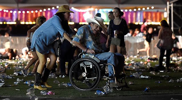 A man in a wheelchair is taken away from the scene. Source: Getty Images