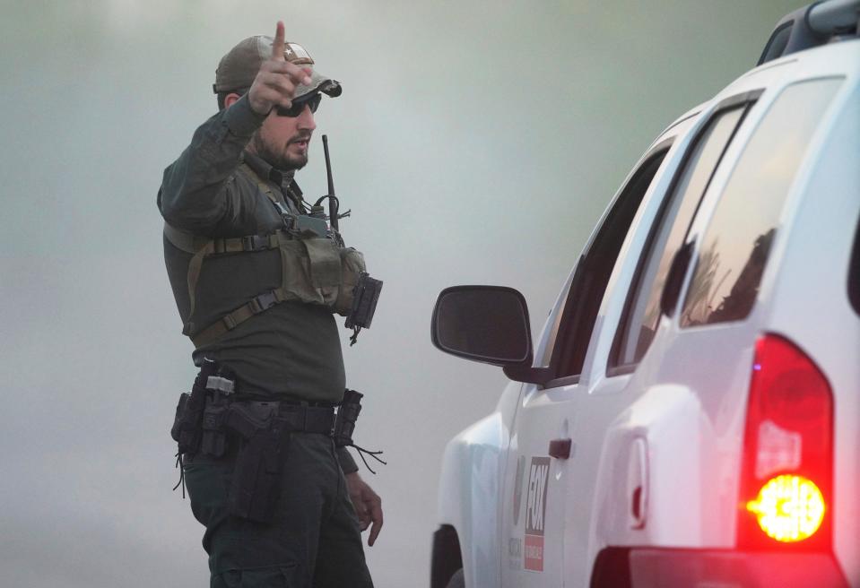 A U.S. Customs and Border Protections agent divert members of the media away from the crash site involving a U.S. Border Patrol and CBP and Marine Operations helicopter in a field just north of the Rio Grande Friday, March 8, 2024, south of La Grulla, Texas. A helicopter carrying three National Guard members and a Border Patrol agent crashed along the U.S.-Mexico border in Texas on Friday, killing three of the people on board, a county official said.