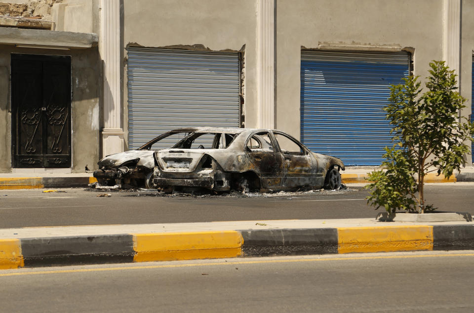 The remains of a car damaged in clashes stands in a street in the Libyan capital of Tripoli on Friday, July 22 2022. One of Libya’s rival governments on Friday called on militias to stop fighting, after clashes broke out in the country’s capital, Tripoli overnight, killing at least one civilian and forcing around 200 people to flee the area(AP Photo/Yousef Murad)
