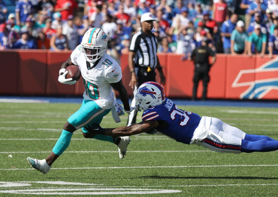 Dolphins receiver Tyreek Hill tries to slip a tackle by Bills Dane Jackson.