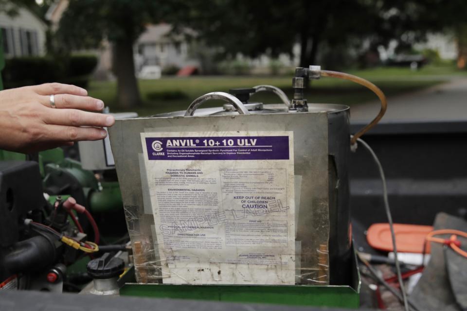 Chris Gagnon, field operations manager for the East Middlesex Mosquito Control Project, points out the type of product that will be sprayed for mosquito control on Wednesday, July 8, 2020, prior to driving through a neighborhood in Burlington, Massachusetts. Officials are preparing for another summer with a high number of cases of eastern equine encephalitis, a rare but severe neurological illness transmitted by mosquitoes that hit the state particularly hard last summer. (AP Photo/Charles Krupa)