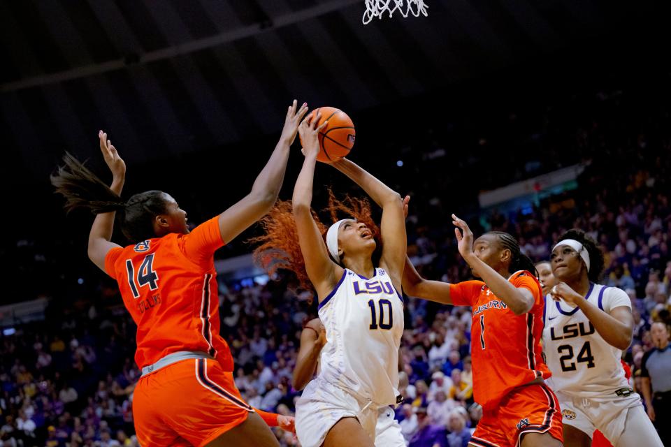 Auburn forward Taylen Collins (14) and forward Celia Sumbane (1) defend LSU's Angel Reese during the second half of their game at Pete Maravich Assembly Center in Baton Rouge, Louisiana on Feb. 22, 2024.
