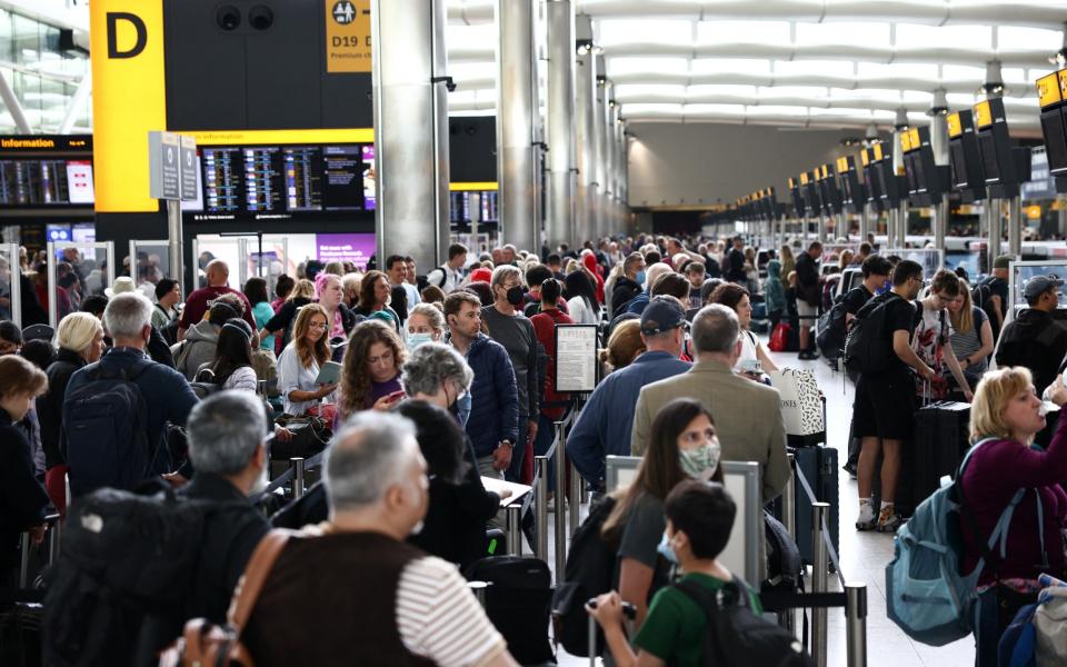 Passengers queue inside the departures terminal of Terminal 2 at Heathrow Airport in London - HENRY NICHOLLS /REUTERS