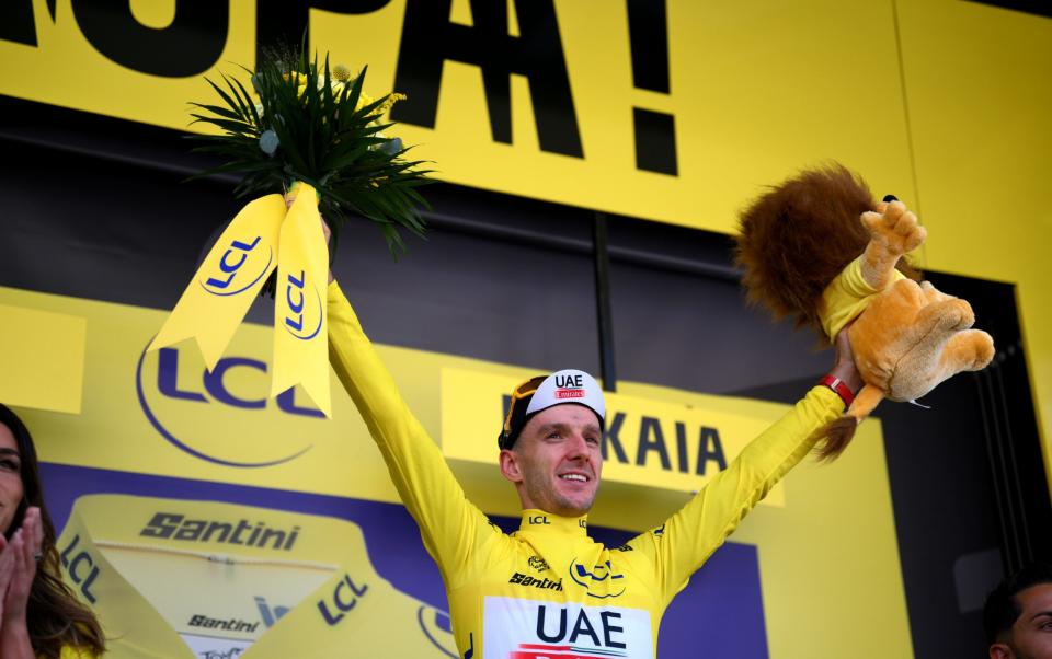 Adam Yates takes the yellow jersey on the podium after winning stage one