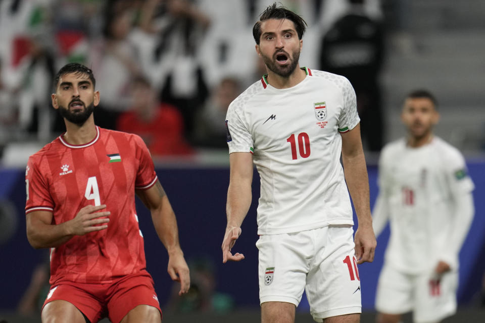 Iran's Karim Ansari Fard, right, reacts after scoring the opening goal of his team during the Asian Cup Group C soccer match between Iran and Palestine at the Education City Stadium in Al Rayyan, Qatar, Sunday, Jan. 14, 2024. (AP Photo/Aijaz Rahi)