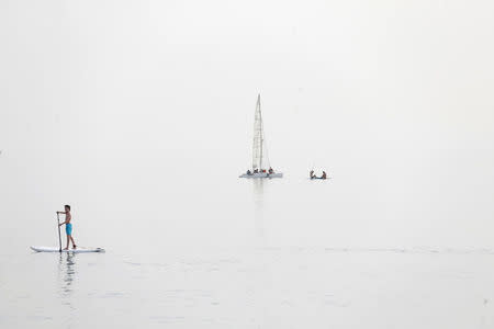 A sap surfer stands on a board in the Mediterranean Sea in Tel Aviv, Israel April 9, 2016. The picture was created by exposing for the shadows on a hazy day. REUTERS/Baz Ratner