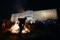 A bonfire staged by farmers burns outside of the Greek parliament in Athens during a rally against pension reform on February 12, 2016