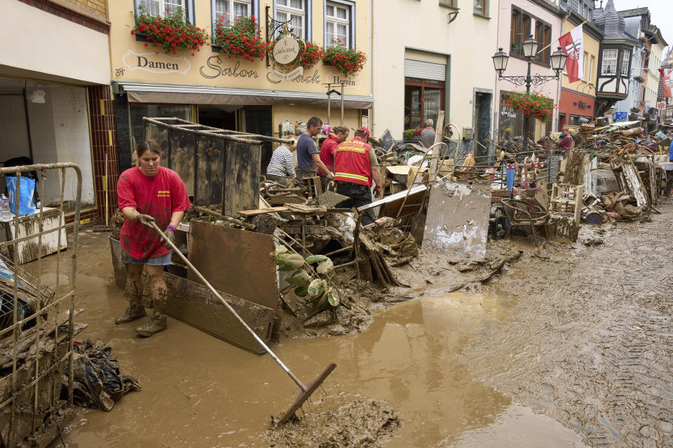 Residents and shopkeepers are trying to clear mud from their homes and move unusable furniture outside in Ahrweiler, western Germany, Saturday, July 17, 2021. Heavy rains caused mudslides and flooding in the western part of Germany. Multiple have died and are missing as severe flooding in Germany and Belgium turned streams and streets into raging, debris-filled torrents that swept away cars and toppled houses. (Thomas Frey/dpa via AP)