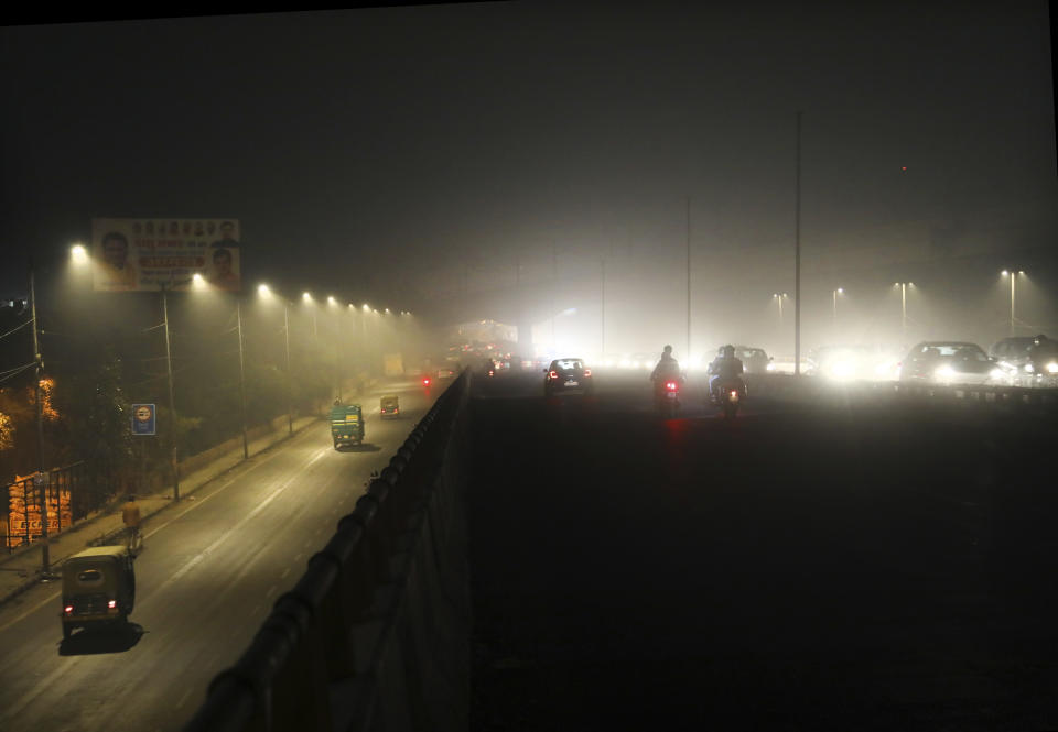 Commuters drive on a road engulfed in smog in New Delhi, India, Thursday, Nov. 5, 2020. India is grappling with two public health emergencies: critically polluted air and the pandemic. Nowhere is this dual threat more pronounced than in the Indian capital New Delhi, where the spike in winter pollution levels has coincided with a surge of COVID-19 cases. (AP Photo/Manish Swarup)