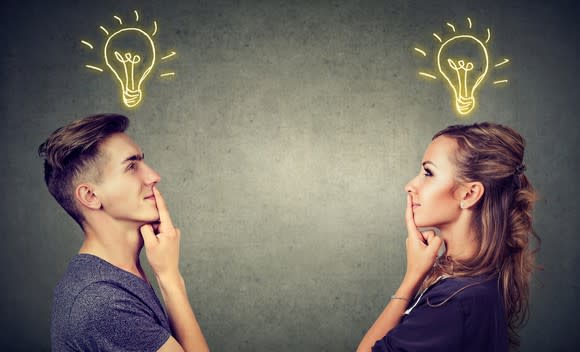 A standing man and woman with drawings of light bulbs lit up above them.