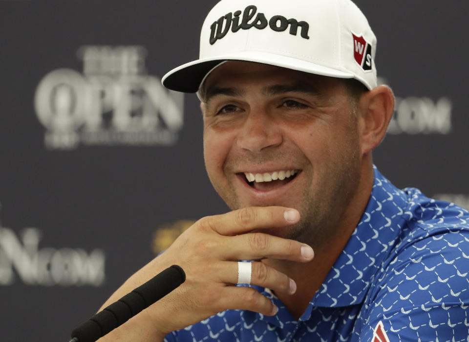 Gary Woodland of the United States smiles as he listens to a question from the media during a press conference ahead of the start of the British Open golf championships at Royal Portrush in Northern Ireland, Tuesday, July 16, 2019. The British Open starts Thursday. (AP Photo/Matt Dunham)