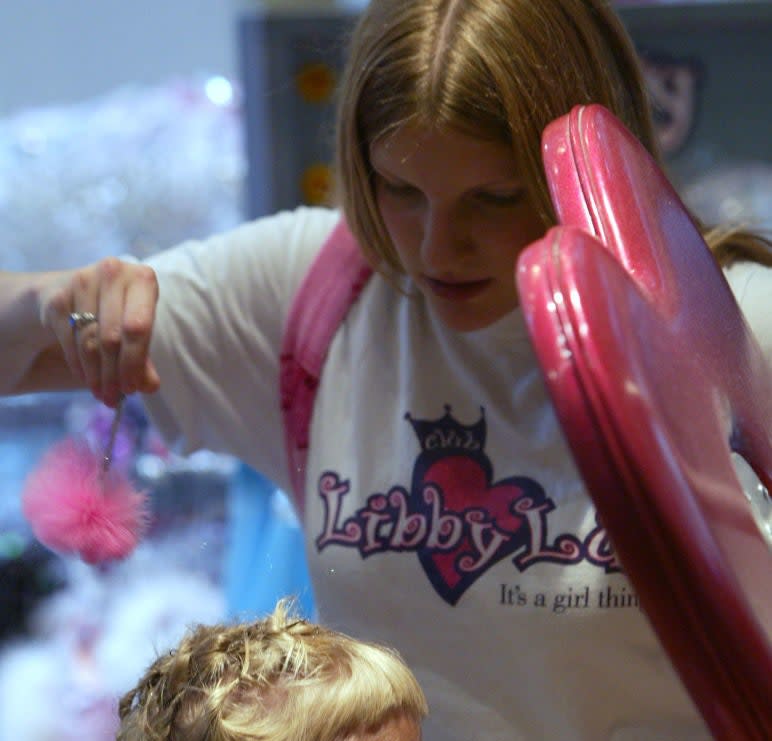 A little girl wearing a Club Libby Lu shirt