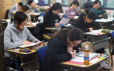 Students prepare to take the annual College Scholastic Ability Test, a standardised exam for college entrance, at a high school in Seoul on November 23, 2017 - Credit: AFP