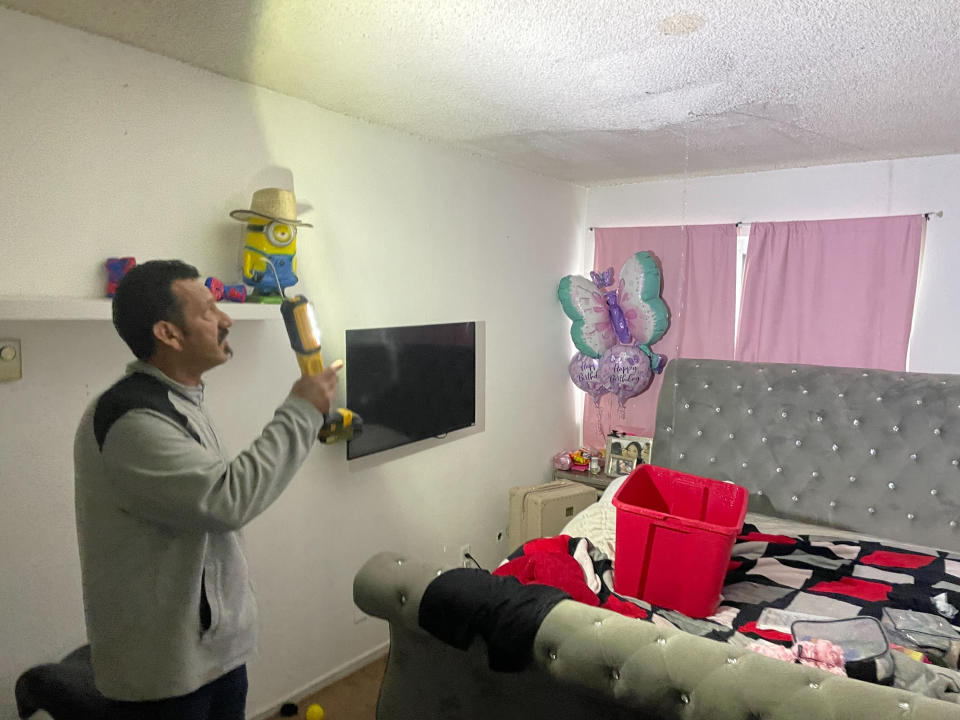 Renter Jose Alvarez looks at streams of water pouring into his family's bedrooms as they tried to salvage belongings from the South San Francisco apartment building which had its roof partially blown off by wind gust in San Francisco Wednesday, Jan. 11, 2023. (AP Photo/Haven Daley)