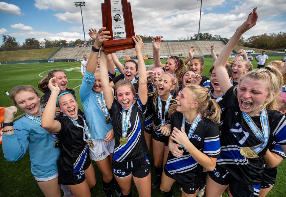 Lakeland Christian  Katie Williams and Breanna Newberg hoist the championship trophy after beating Benjamin 2-1 during the 3A Girls FHSAA State Soccer Championship game at Spec Martin Stadium in DeLand.