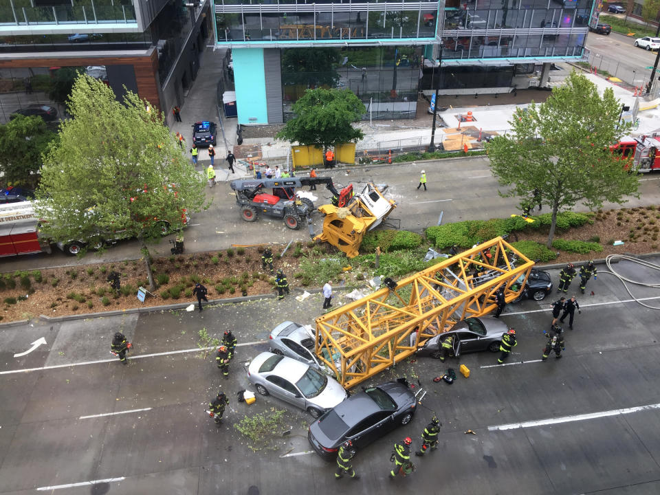 Fire and police crew members work to clear the scene where a construction crane fell from a building on Google's new Seattle campus crashing down onto one of the city's busiest streets and killing multiple people on Saturday, April 27, 2019. (AP Photo/Frank Kuin)