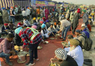 Indian farmers protesting new agriculture eat lunch during a blockade at the Delhi-Haryana state border, Monday, Nov. 30, 2020. Indian Prime Minister Narendra Modi tried to placate thousands of farmers protesting new agriculture laws Monday and said they were being misled by opposition parties and that his government would resolve all their concerns. (AP Photo/Rishi Lekhi)