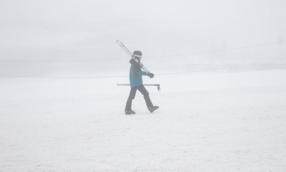 Skiers return to the carpark after fresh snowfalls and a complete white out at Perisher ski fields