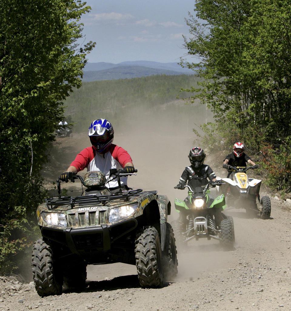 FILE - In this Sunday, May 23, 2010 file photo, Jude Stohl leads Leigha Cicchetto and his son Ethan Stohl on a ride through Jericho Park's trail system in Berlin, N.H. In New Hampshire, a new interconnected all-terrain vehicle trail system dubbed "Ride the Wilds" will officially open June 15, 2013, capping years of work by more than a dozen off-road vehicle clubs who worked with state agencies and local communities to link 1,000 miles of trails across Coos County. (AP Photo/Jim Cole, File)