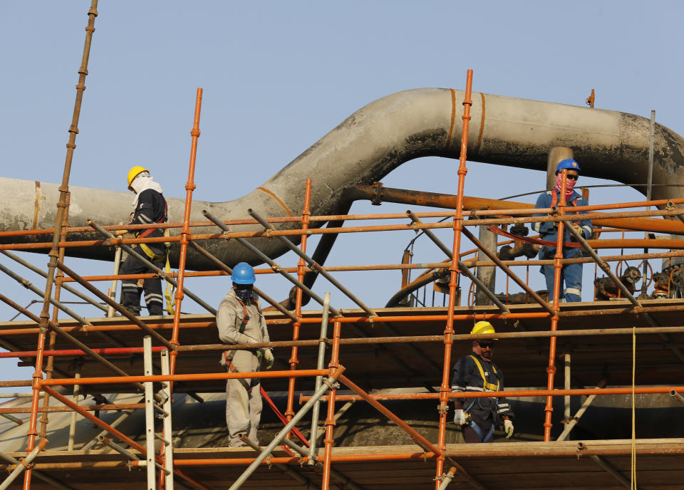During a trip organized by Saudi information ministry, workers fix the damage in Aramco's oil separator at processing facility after the recent Sept. 14 attack in Abqaiq, near Dammam in the Kingdom's Eastern Province, Friday, Sept. 20, 2019. Saudi Arabia allowed journalists access Friday to the site of a missile-and-drone attack on a facility at the heart of the kingdom's oil industry, an assault that disrupted global energy supplies and further raised tensions between the U.S. and Iran. (AP Photo/Amr Nabil)