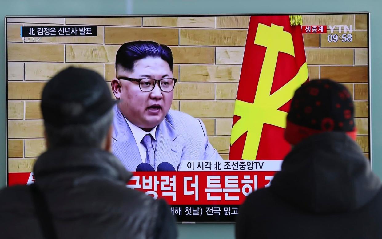 Passers-by in Seoul, South Korea, watch a TV broadcast of Kim Jong-un's New Year address - AP